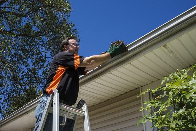 repairman sealing and reattaching a loose and sagging gutter in Fort Carson CO